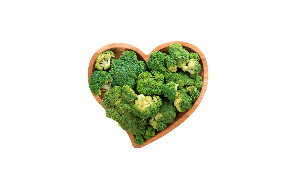 7 heart shaped fresh green broccoli on wooden plate isolated on white.